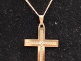 une croix en or sur un fond noir, avec une chaîne en or