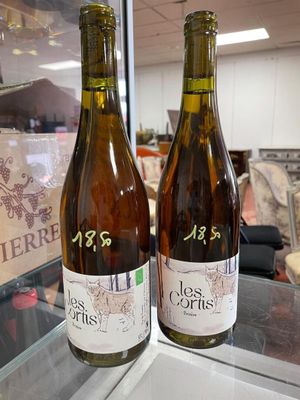 two bottles of wine sitting on a counter in a store