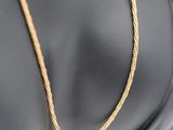 a close up of a gold necklace on a mannequin mannequin