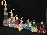 cinq vases en verre de couleurs différentes et un robinet en laiton sur fond noir