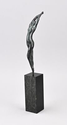 sculpture en bronze représentant une femme debout sur un socle, les bras tendus