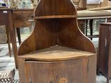 a wooden corner cabinet with a flower design on it