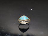 a close up of a ring with a turquoise stone in it