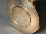 a silver plate with a pink stone in it