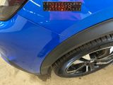 the rear end of a blue car with a sticker on it ' s bumper