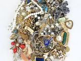 a pile of assorted jewelry on a white surface