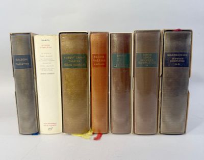 several books are lined up in a row on a white surface