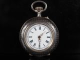 une montre de poche en argent avec des chiffres romains sur le cadran