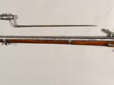 an old rifle with a wooden barrel and a metal handle