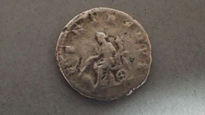 an old coin with a man riding a horse on it