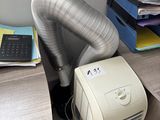 a small air conditioner sitting on a desk next to a pile of files