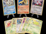 Plusieurs cartes Pokémon sont disposées en rangée sur un fond noir
