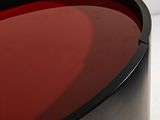 red liquid in a black container on a white surface