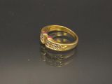 une bague en or sertie d'une pierre rose sur un fond noir
