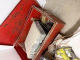 a pile of assorted items on the floor next to a red box