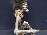 a sculpture of a person sitting on a chair