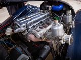 a close up of a car engine with a man standing next to it