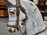a white wooden horse with a bridle on it ' s head