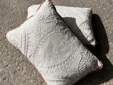 two pillows sitting on the ground next to each other
