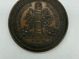 une image représentant une pièce de monnaie en bronze sur laquelle figure une tour horloge