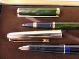 several pens are lined up in a box on a brown surface