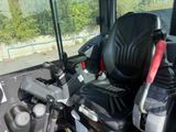 a black seat on a bus with a red handle