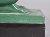 a green vase sitting on top of a black base