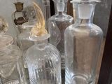 many glass bottles on a glass shelf in a room
