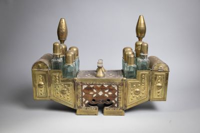 a gold and glass desk with three bottles on top of it
