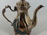 a silver tea pot with a handle and a handle on it