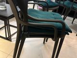 several chairs and a table in a room with a vase of flowers on the table