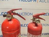 two fire extinguisors sitting next to each other