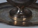a silver plate with a bowl on top of it