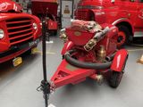 a red fire truck with a hose attached to the back of it