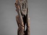 a wooden statue of a man holding his head in his hands