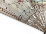 a close up of a fan with a painting on it