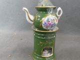 a green tea pot with a tea kettle on it