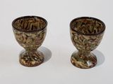 two brown and green vases sitting on a white surface