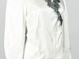 une photo d'un mannequin portant une chemise blanche bordée de dentelle noire