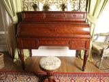 a small stool sitting in front of a piano in a living room