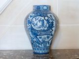 a blue and white vase sitting on a counter