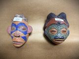 two masks that are sitting on a brown surface