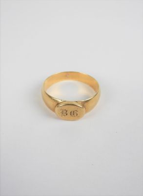 gros plan d'une bague en or sur une surface blanche