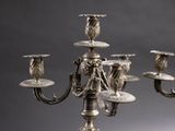 a silver candelab with four candles on top of it