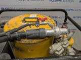 a yellow tank with a hose attached to it next to a yellow fire hydrant
