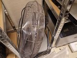 a fan that is sitting on the floor next to a chair