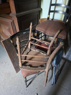 une chaise en bois avec une assise marron, placée dans une pièce