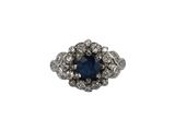 gros plan d'une bague avec une pierre bleue entourée de diamants blancs