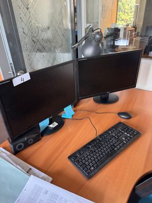 a desk with two computer monitors and a keyboard on it