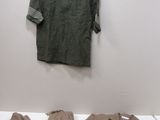a shirt and pants sitting on a bed next to a hanger